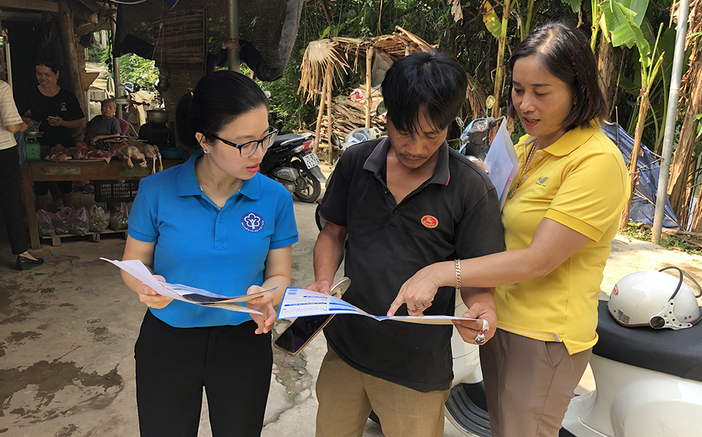 Viên chức BHXH tỉnh và tổ chức dịch vụ thu của Bưu điện tuyên truyền, vận động người dân xã Văn Phú, thành phố Yên Bái tham gia BHXH tự nguyện.